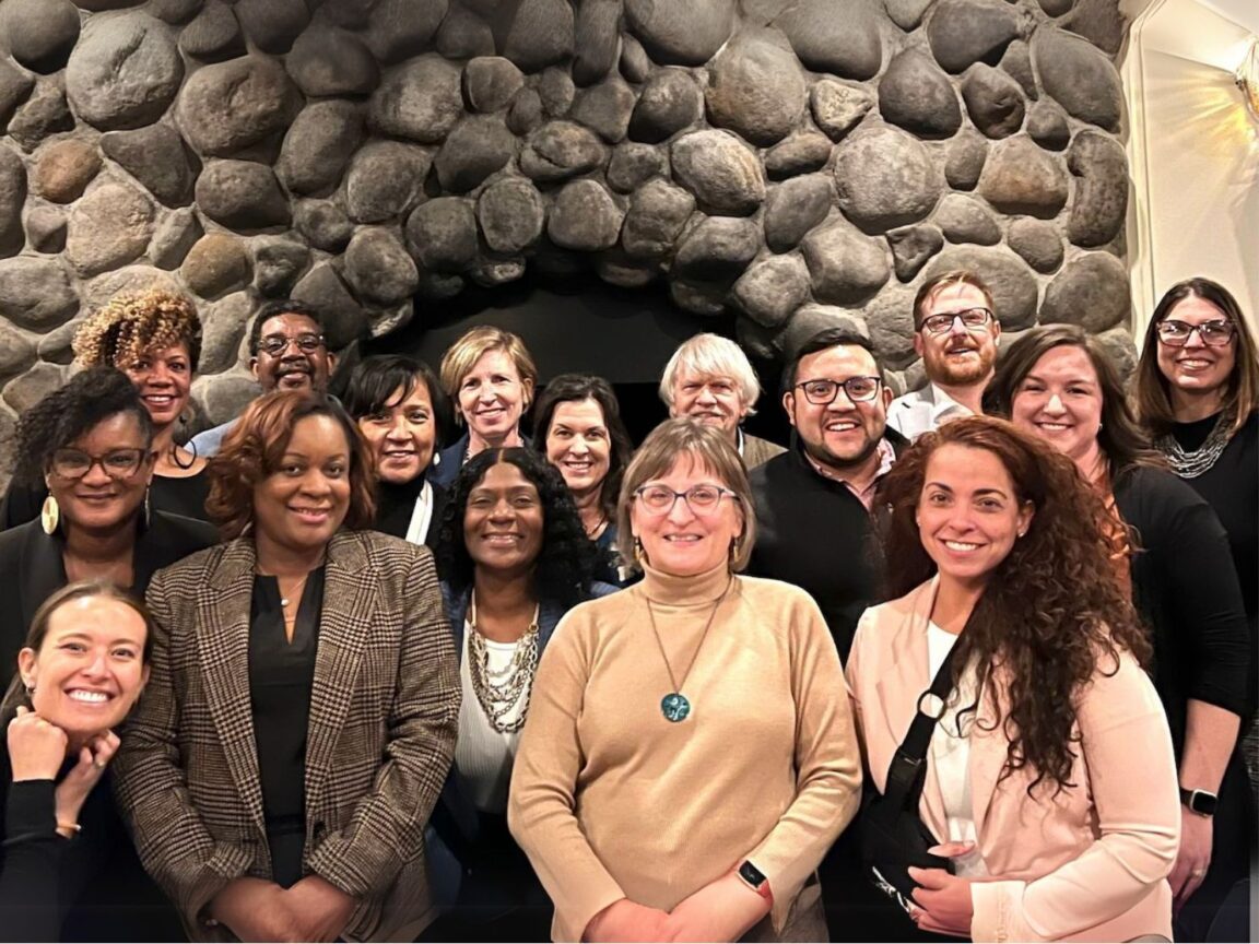 ZSR staff stand in front of a stone chimney