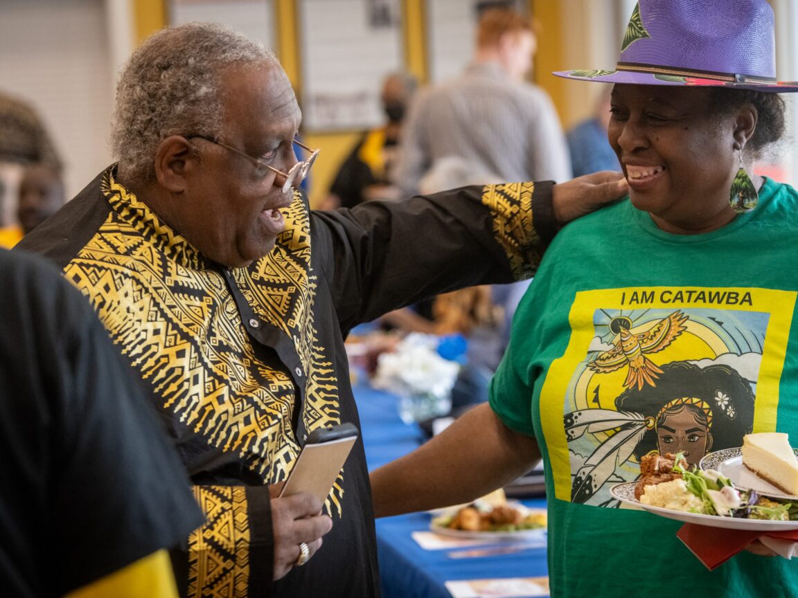 Two people smile and embrace at a community event
