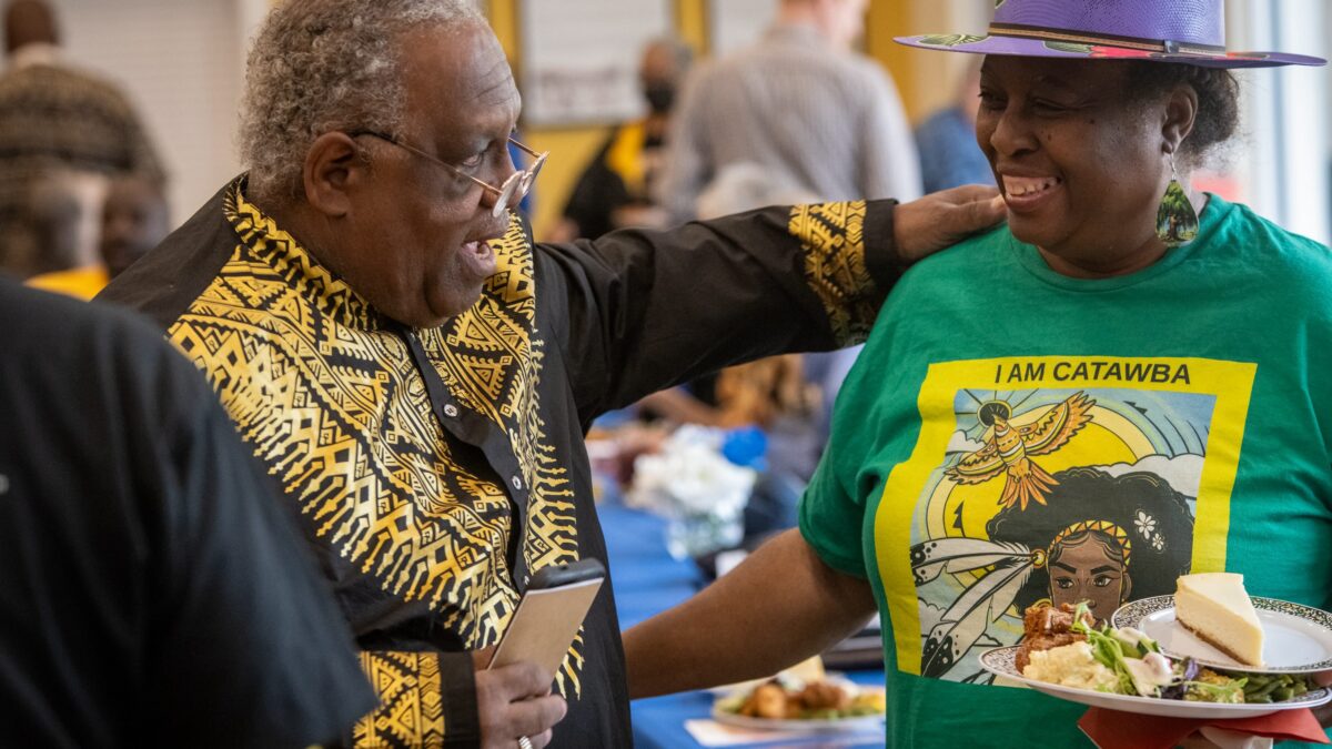 Two people smile and embrace at a community event
