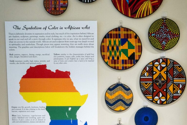 Colorful African fabrics surround a plaque that details the fabrics' history